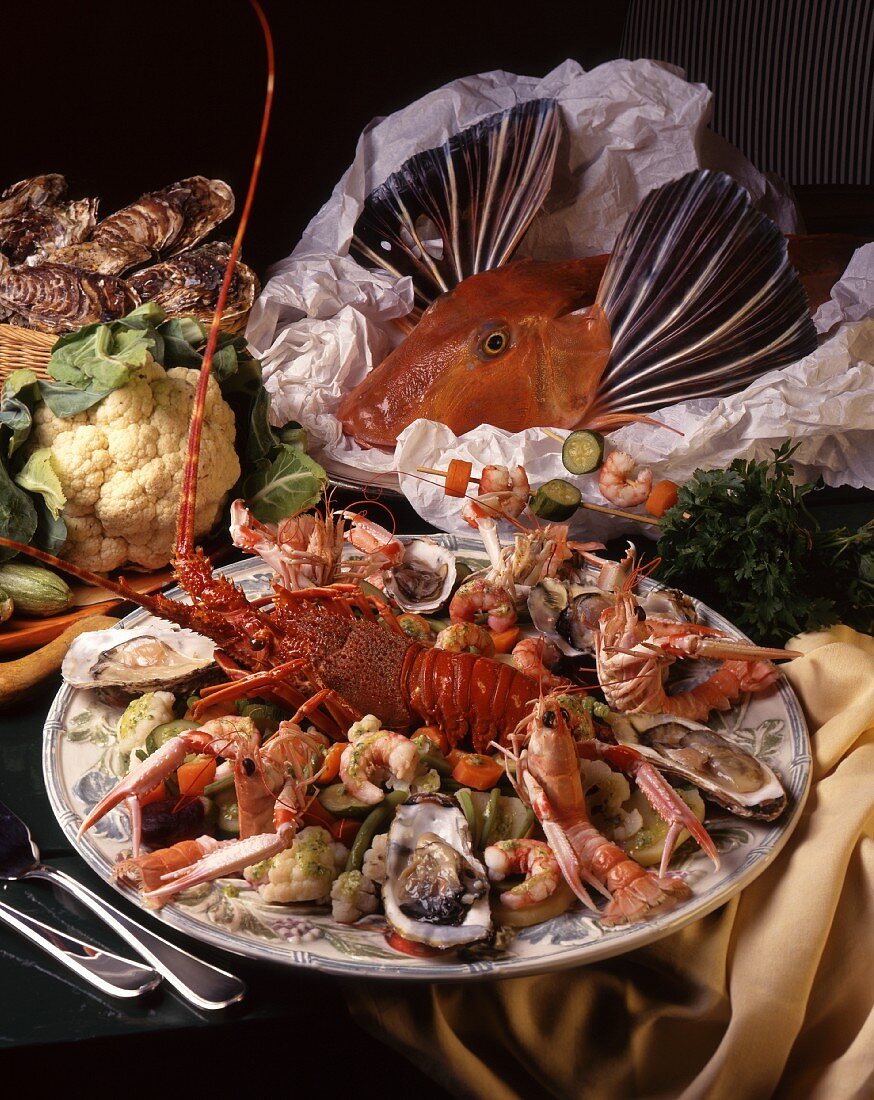 A platter of seafood with a mixture of crustaceans, oysters and vegetables