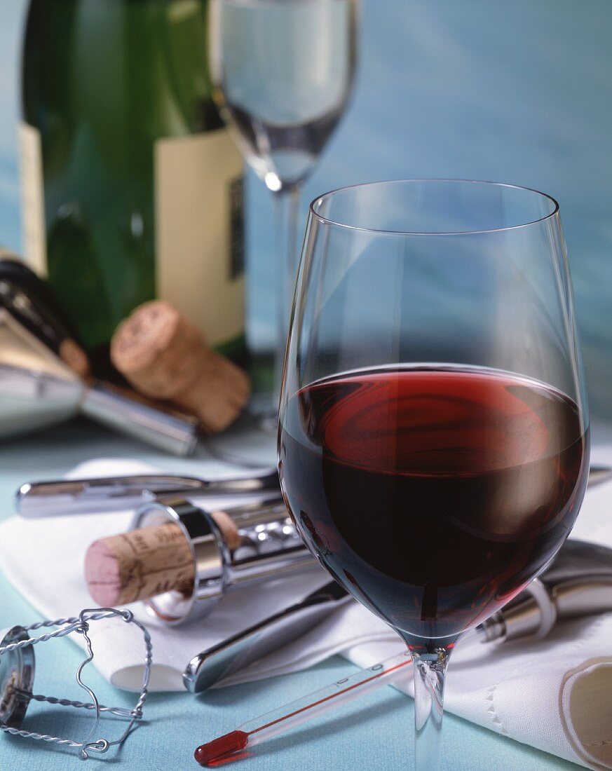 A glass of red wine and wine paraphernalia