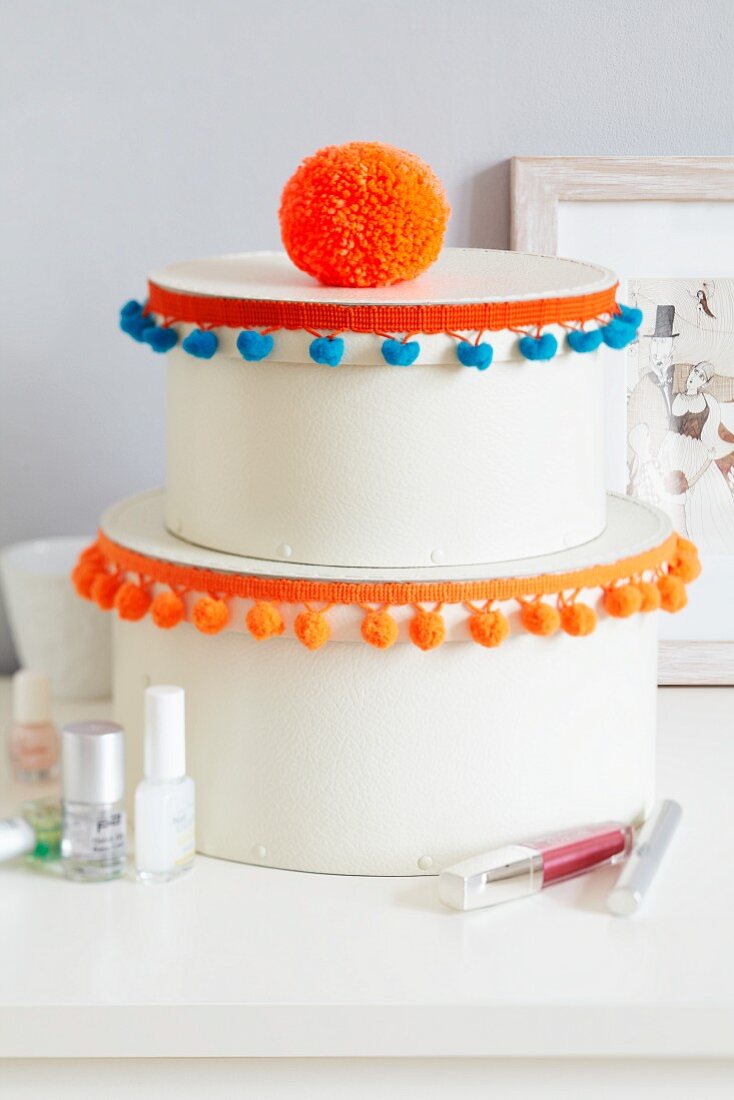 Round boxes decorated with pompom trim