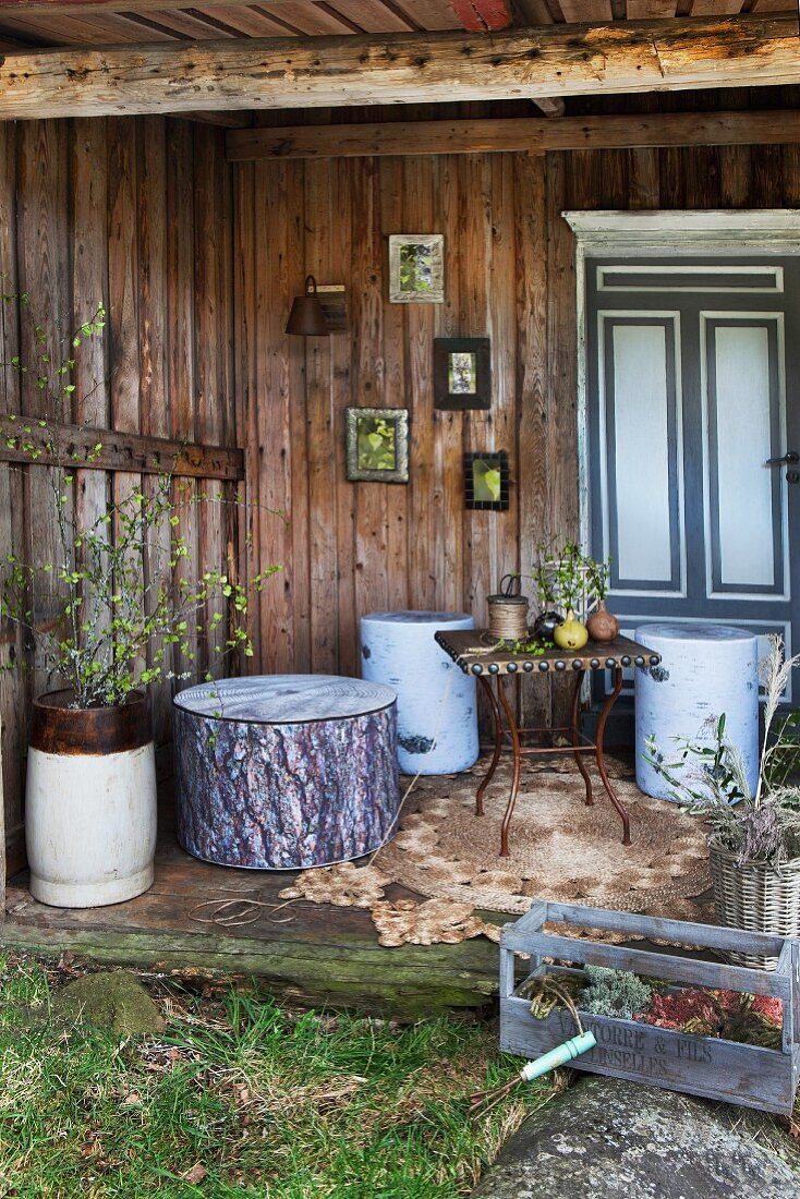 Holzterrasse mit dicken Baumstamm-Hockern