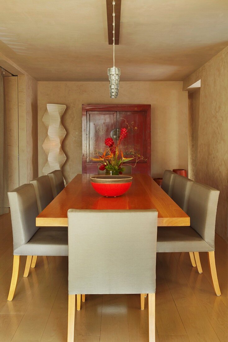 Padded chairs with light gray relation to wooden table in the dining room with retro flair