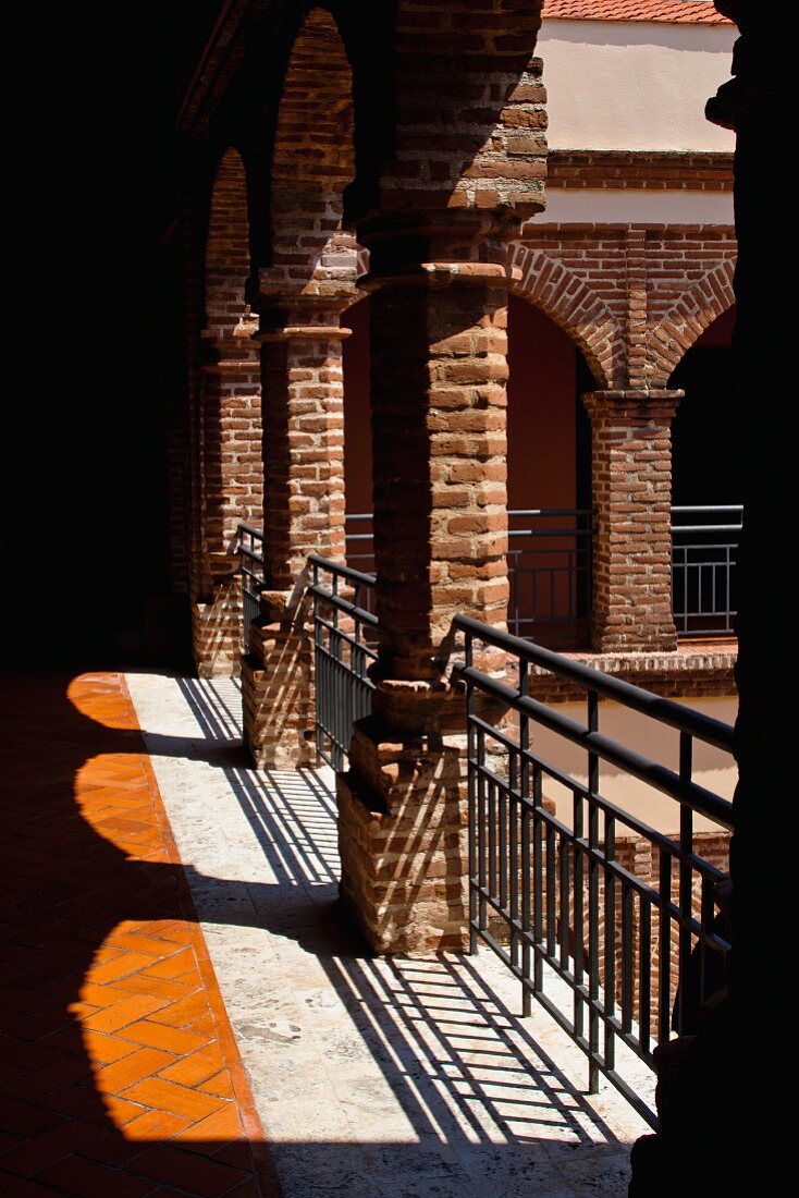 Loggia with metal balustrade and view into courtyard