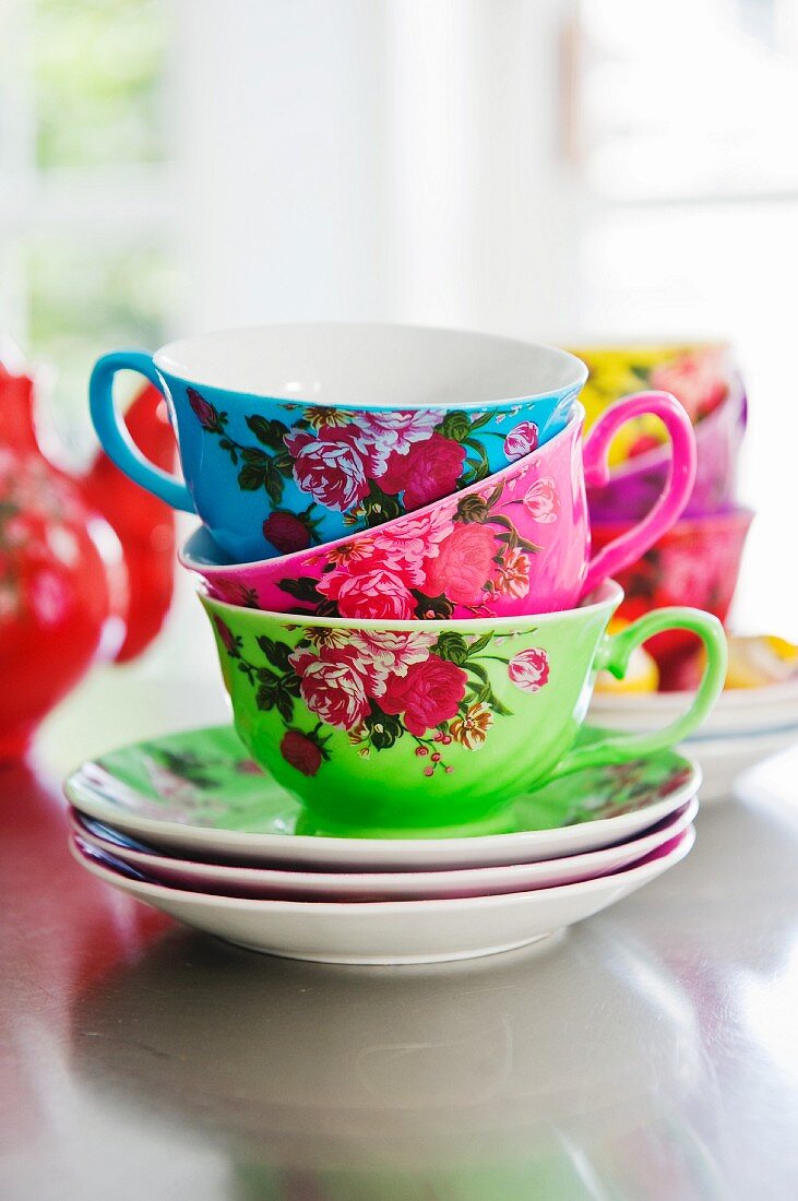 Stacked, rose-patterned teacups in bold colours