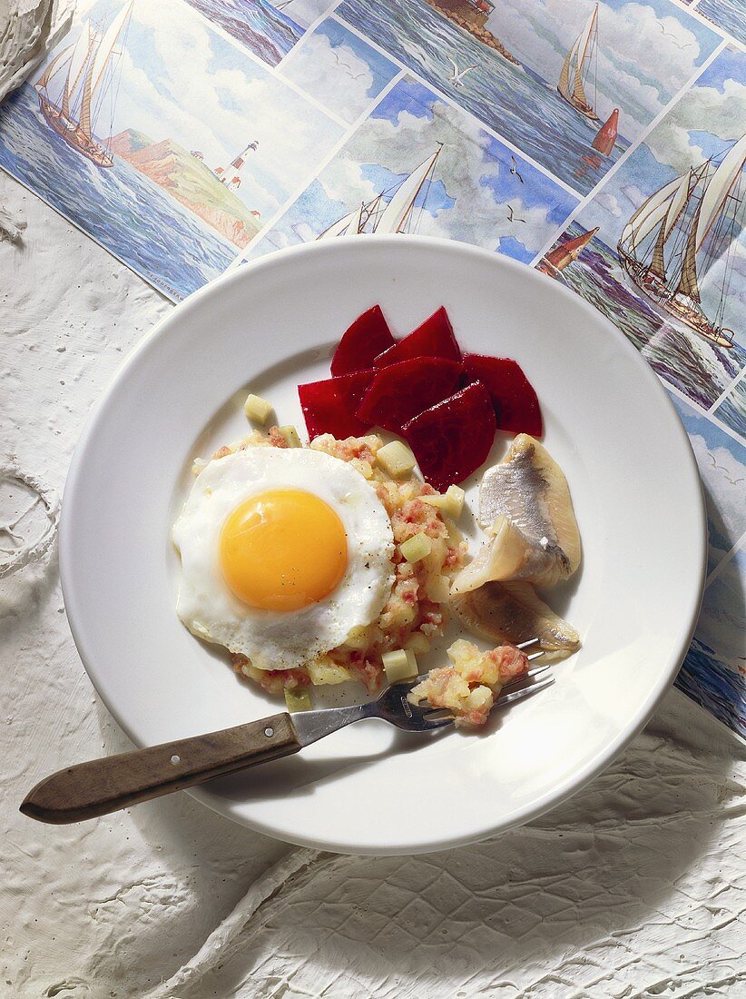 Fried egg on potatoes & leeks with bacon & maties herrings