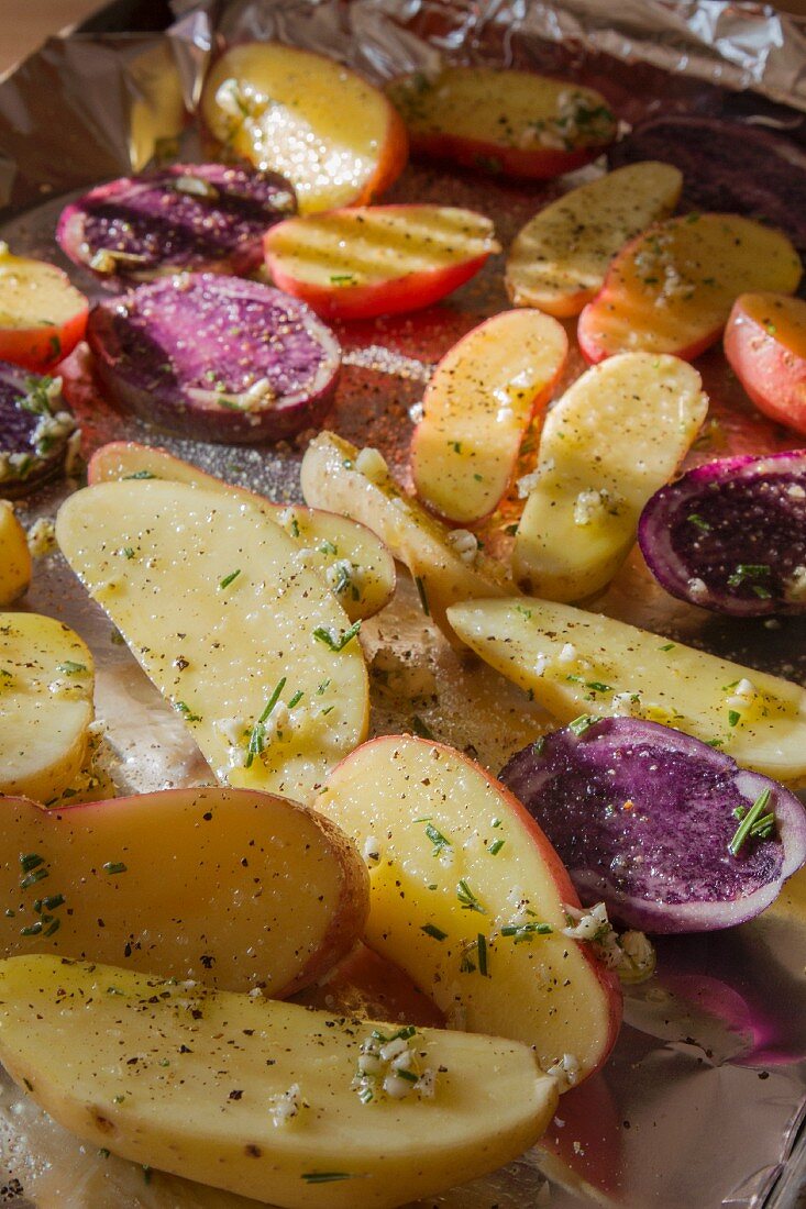 Fingerling and Peruvian Purple Potatoes Seasoned and Ready for Baking on a Foil Lined Pan
