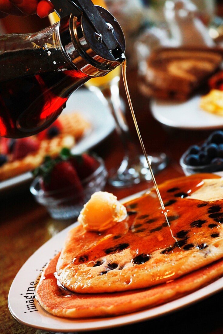 Maple Syrup Pouring Over Blueberry Pancakes