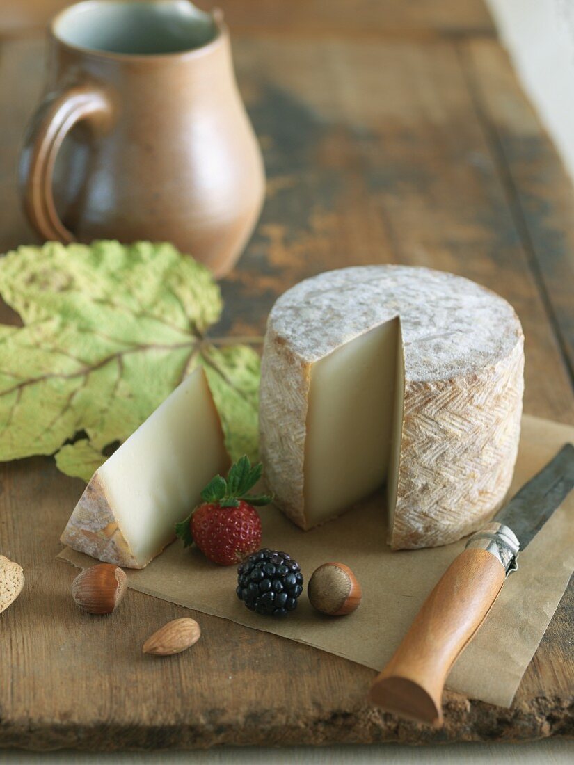 Schafskäse mit Nüssen und Beeren auf Holzbrett