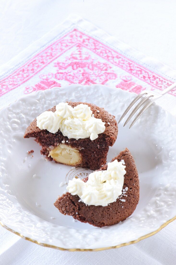 A cocoa and chocolate cupcake with coconut praline and coconut cream