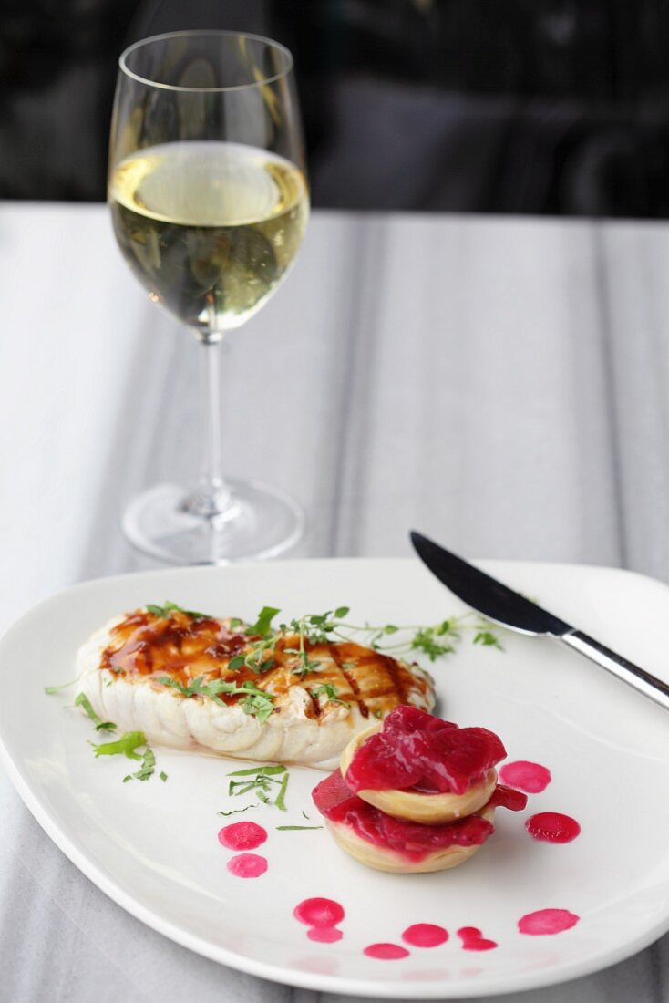 Grilled fish with artichokes and beetroot, and a glass of white wine