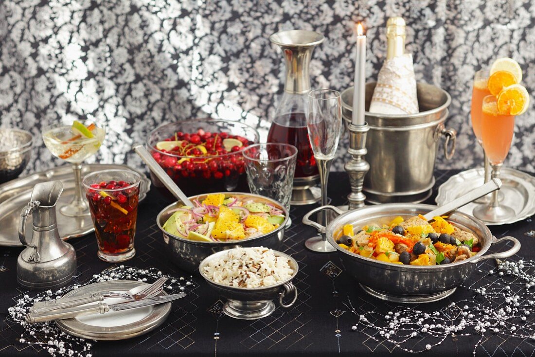 Partybuffet mit Getränken, Salat und Schweinefilet mit Orangen und Oliven