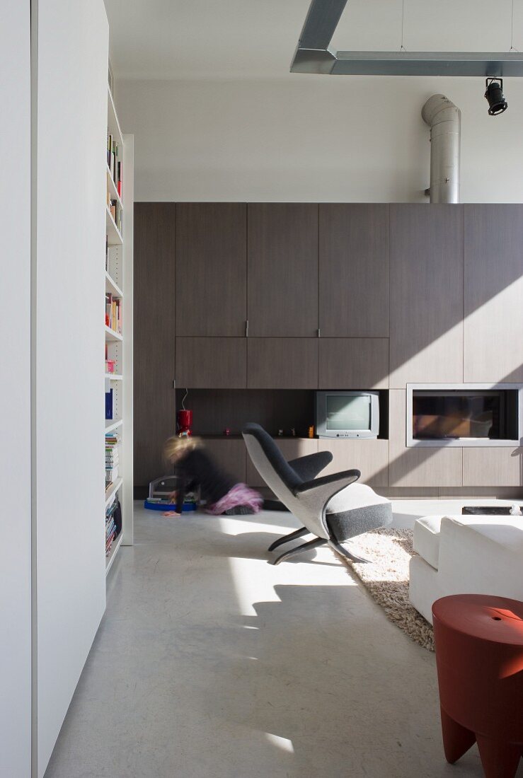 Wohnraum mit Designermöbeln und Einbauwand in einem umgenutztem Schulhaus