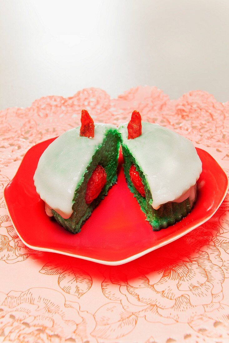 Grüner Muffin mit Himbeeren auf rotem Teller
