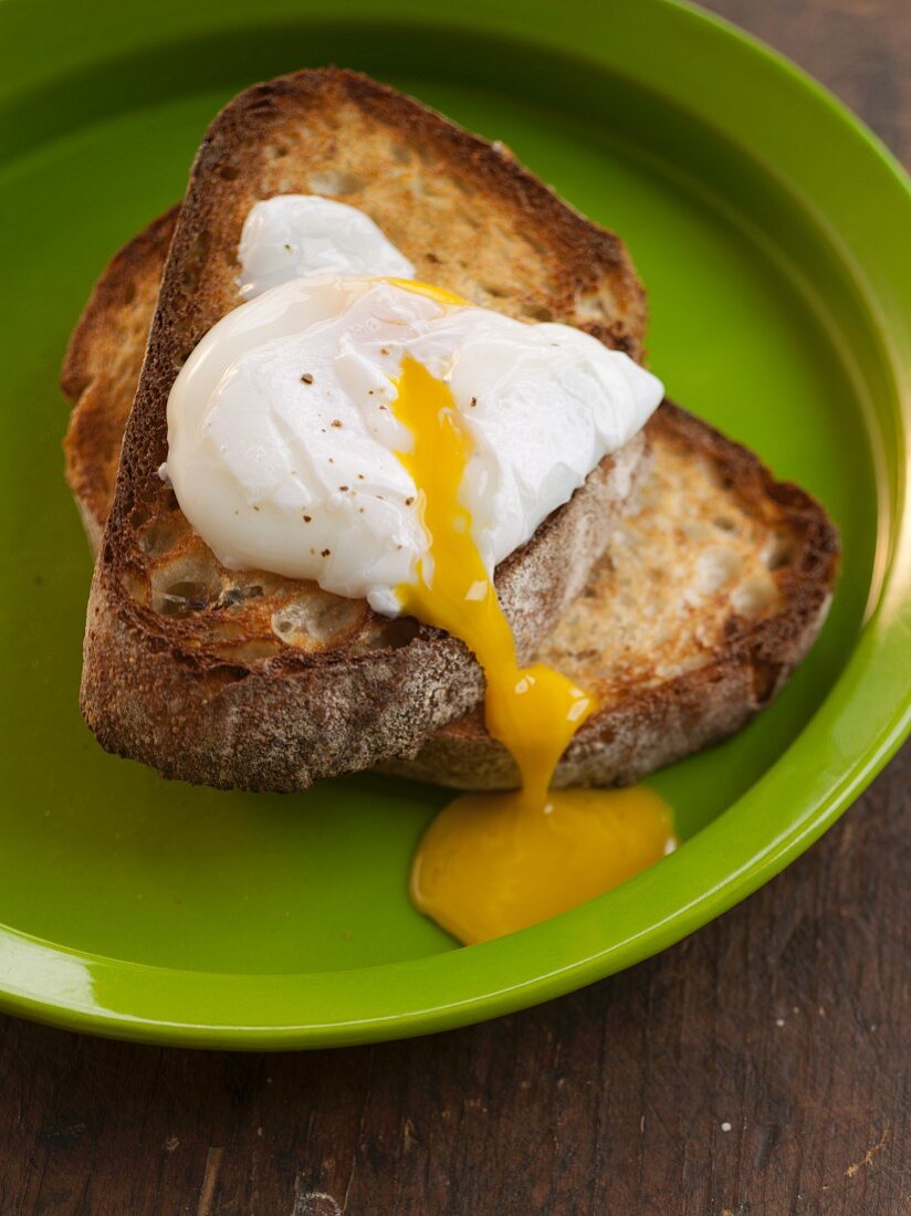 Poached Egg Over Toast with Runny Yolk; On a Green Plate