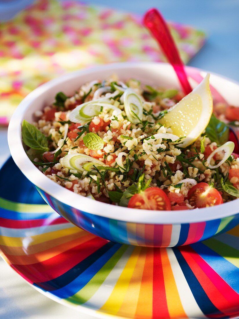 Bowl of Fresh Tabouleh with Lemon Wedges