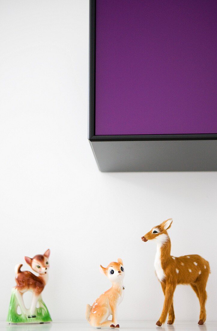 50s-style animal ornaments on shelf below wall-mounted cabinet