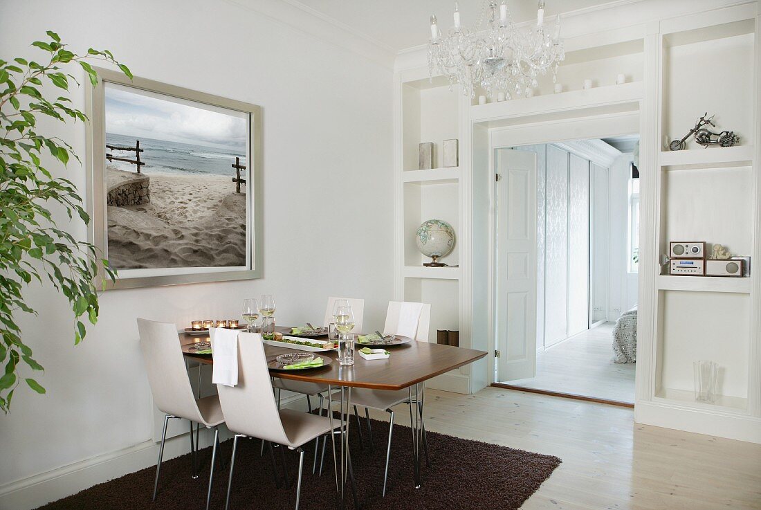 Set dining table against wall with built-in shelving and integrated doorway