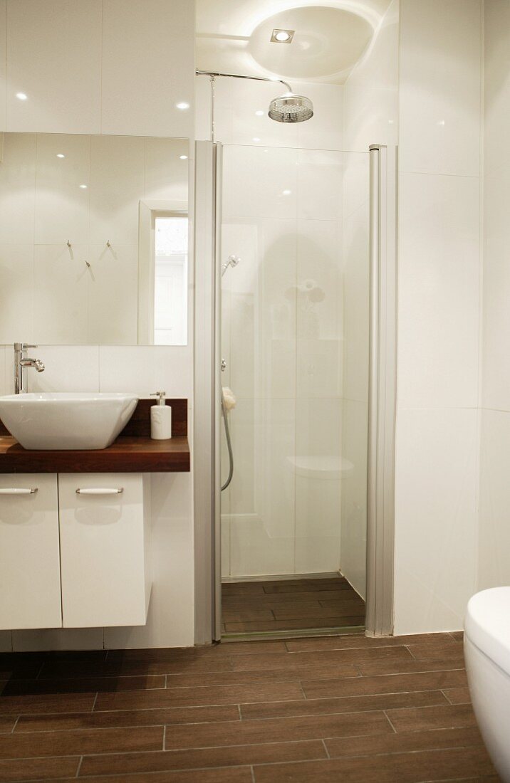 Modernes Designerbad mit abgetrenntem Duschbereich in Weiß mit braunen Bodenfliesen
