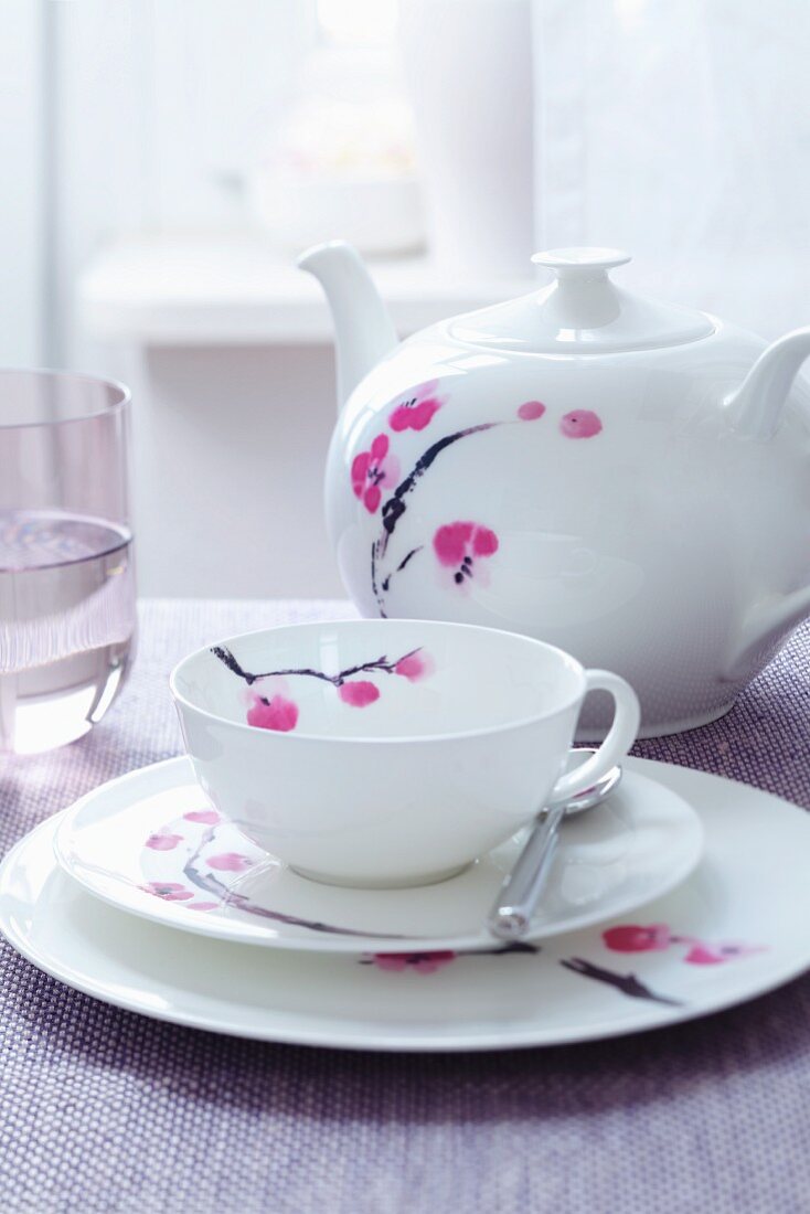 Teegedeck und Teekanne mit Blütenmotiv