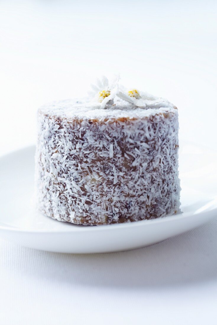 An individual coconut torte with candied daisies