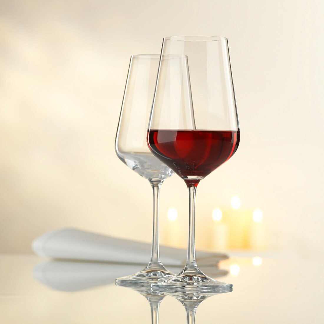 Two wine glasses with a napkin and candles