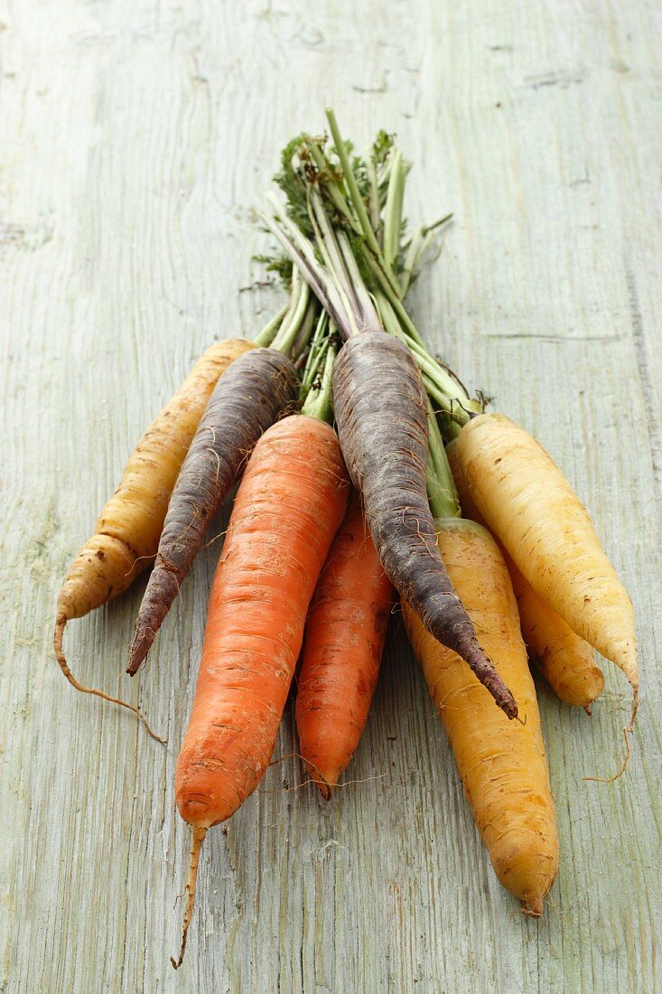 A selection of different coloured carrots (purple, yellow and orange)