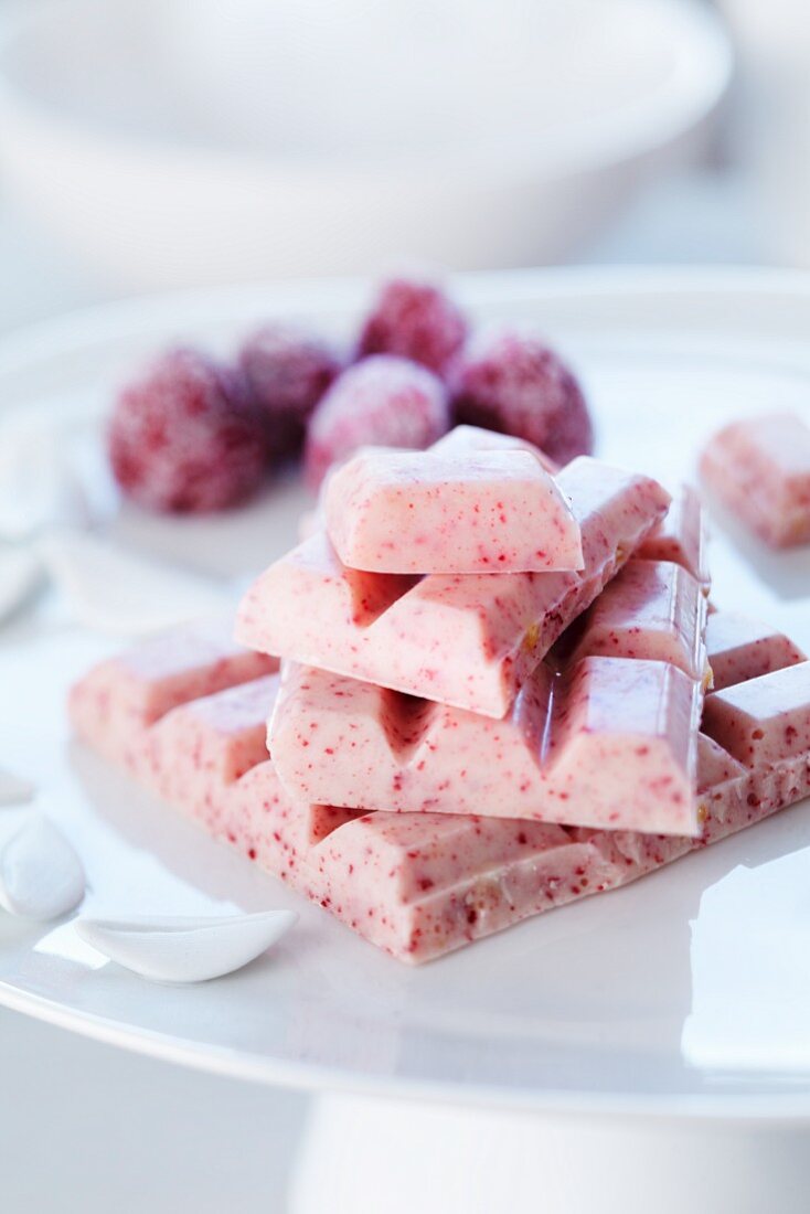 Himbeerschokolade und gezuckerte Himbeeren im Hintergund