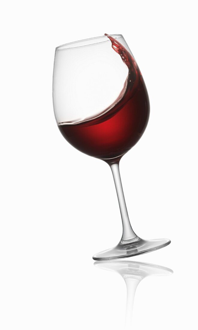 Tilted red wine glass – License Images – 11156710 ❘ StockFood