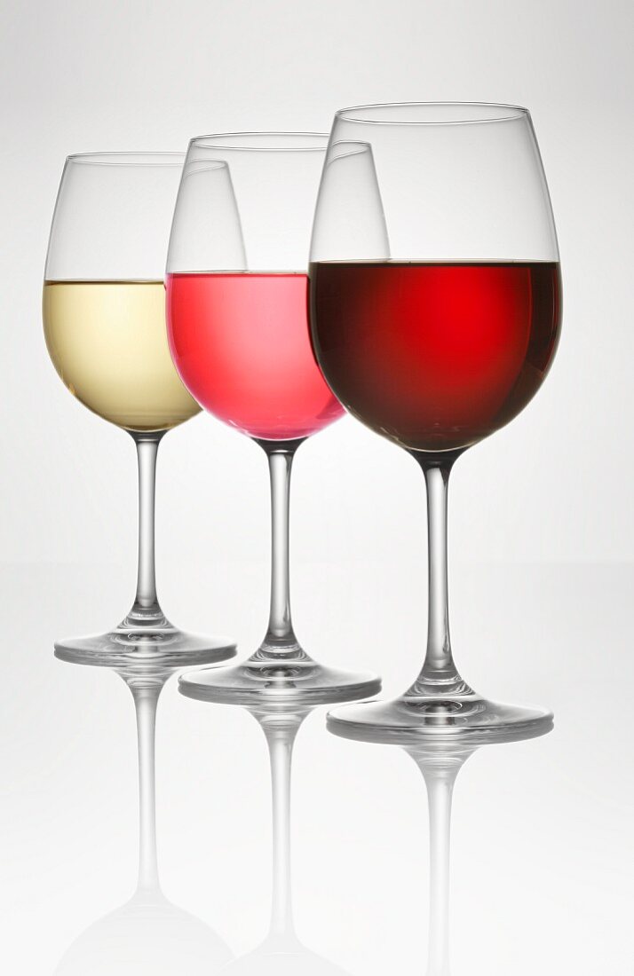 Three wine glasses (of white, rosé, and red wine)