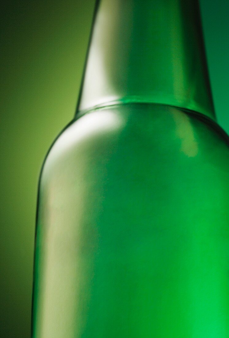 Grüne Bierflasche auf einem grünen Hintergrund (Nahaufnahme)
