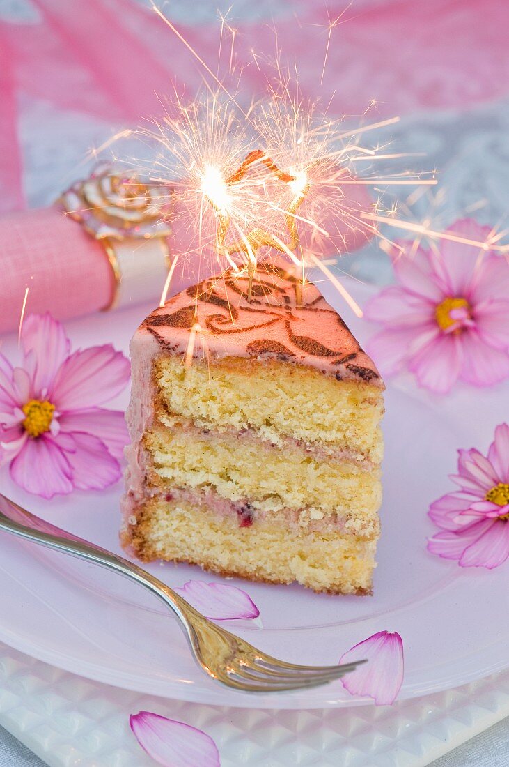 A piece of birthday cake with a sparkler