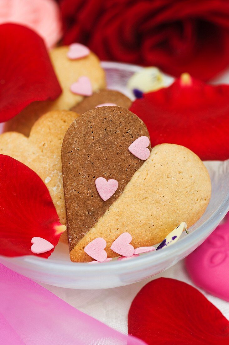 Vanilla and chocolate heart-shaped biscuits with sugar hearts and rose petals