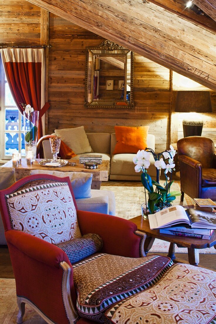 Armchair and footstool in comfortable living room of wooden cabin