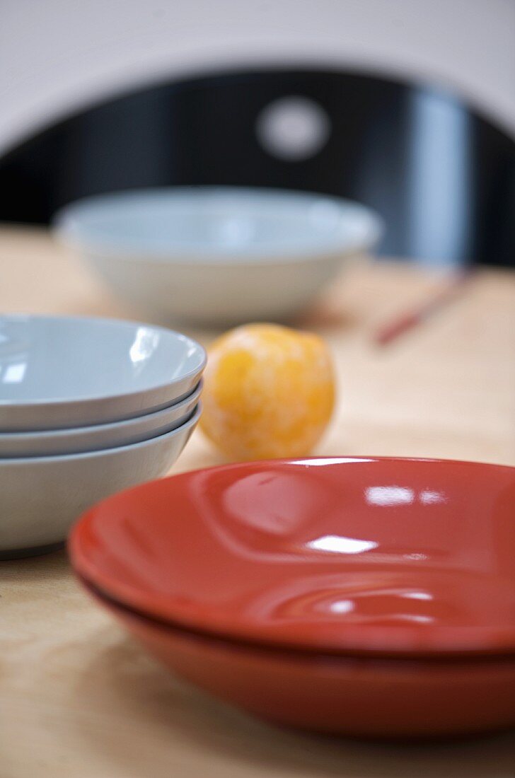 Stacks of different ceramic and china dishes on table