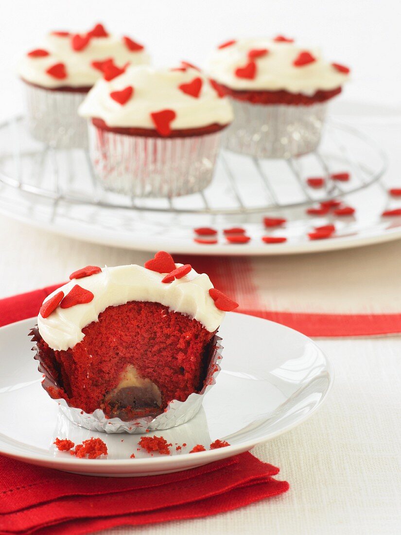 Red Velvet Cupcakes mit roten Zuckerherzen, angebissen