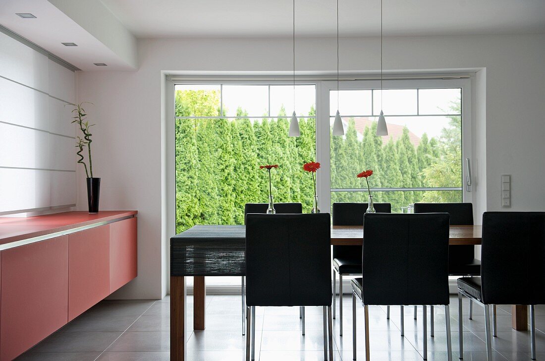 Designer dining room with dining area in front of terrace windows with view of garden