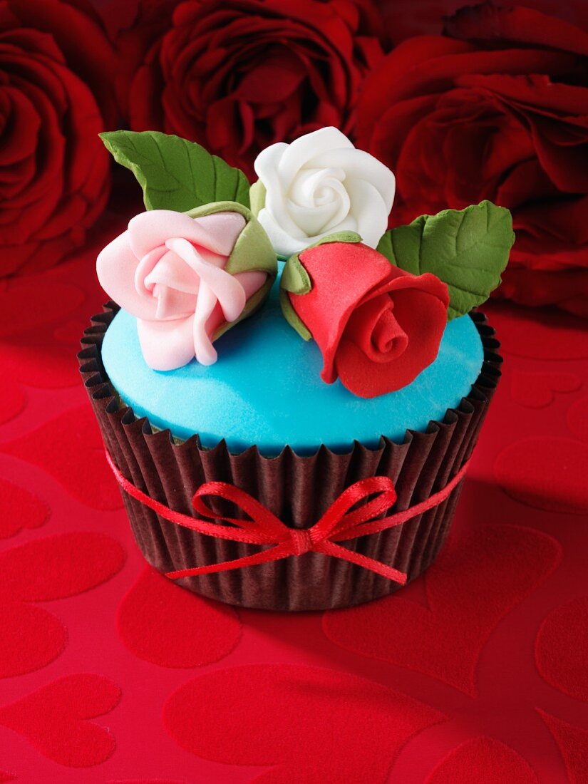 A red velvet cupcake with sugar roses