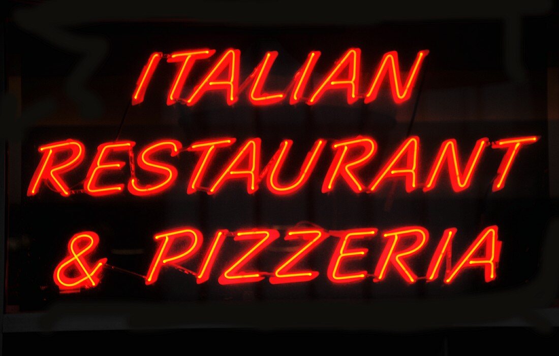 A red neon sign on a pizzeria in Chicago