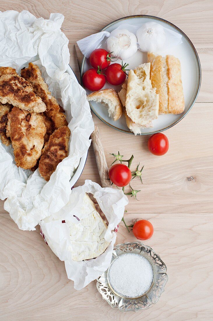 Stillleben mit Brot, Kirschtomaten, Knoblauch und Käse