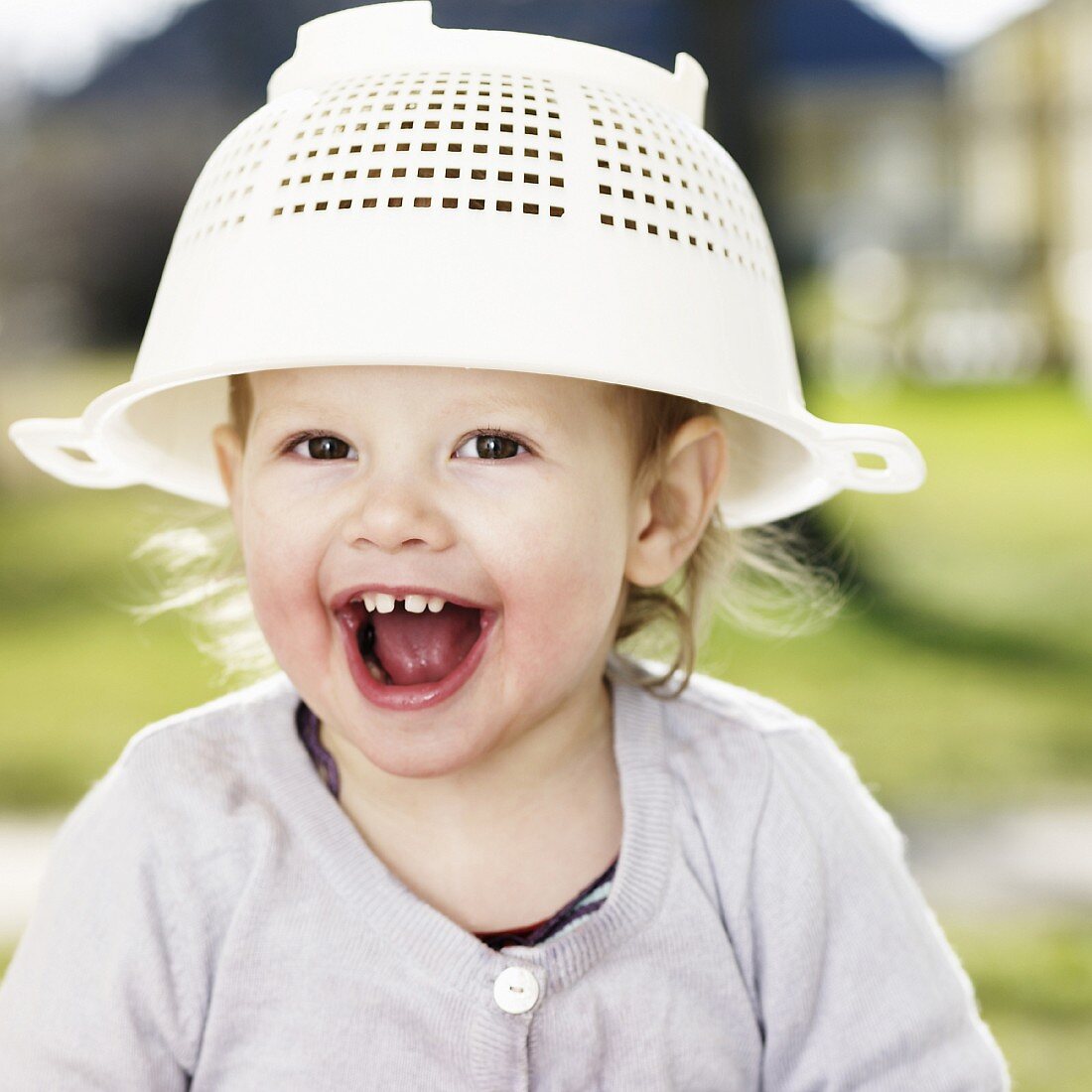A little girl with a plastic colander on her head