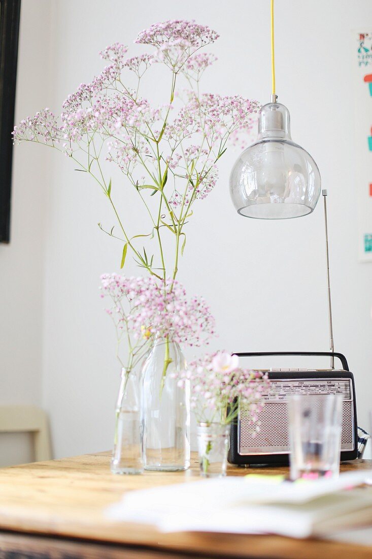 Retro-Radio und Blumenvasen auf einem Holztisch