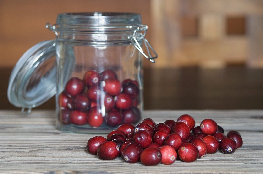 Cranberries in und vor einem Einmachglas