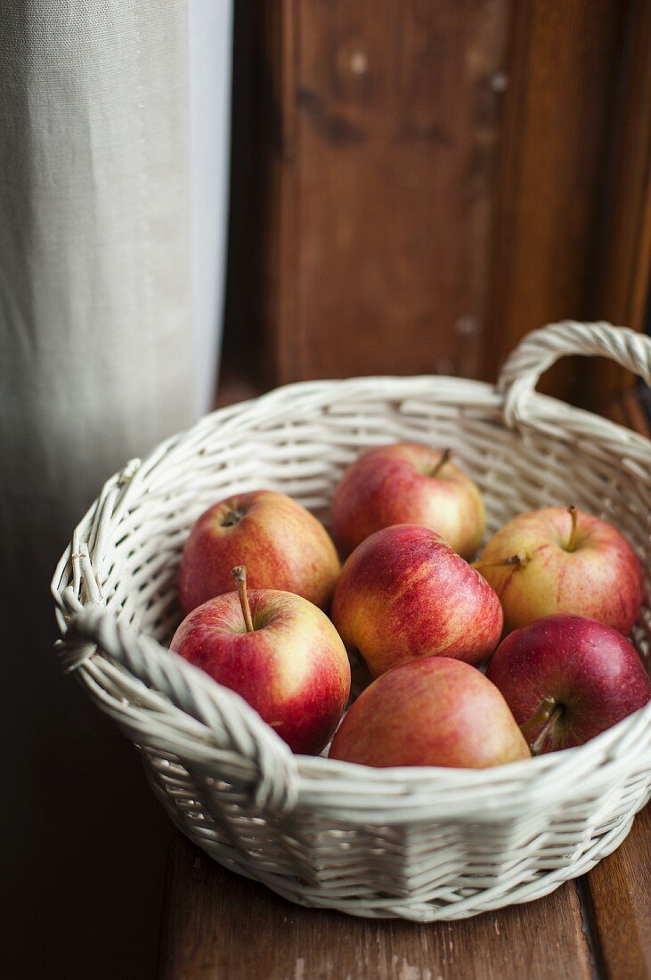 Pink Lady apples in a white basket