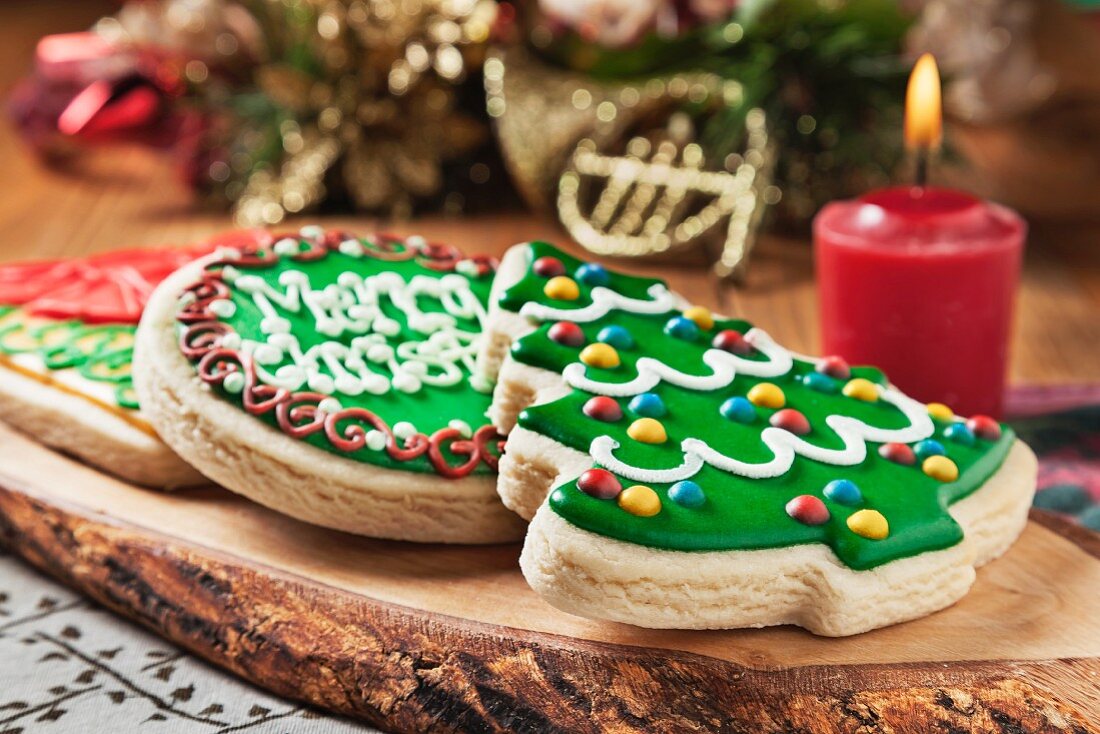 Frosted Christmas Cookies on a Wood Platter; Candle and Christmas Decorations