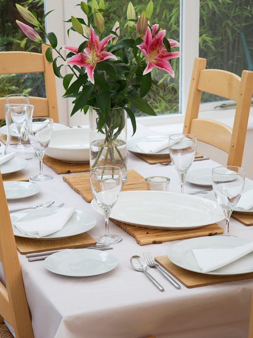 A table laid for a meal in a well-lit room by the window