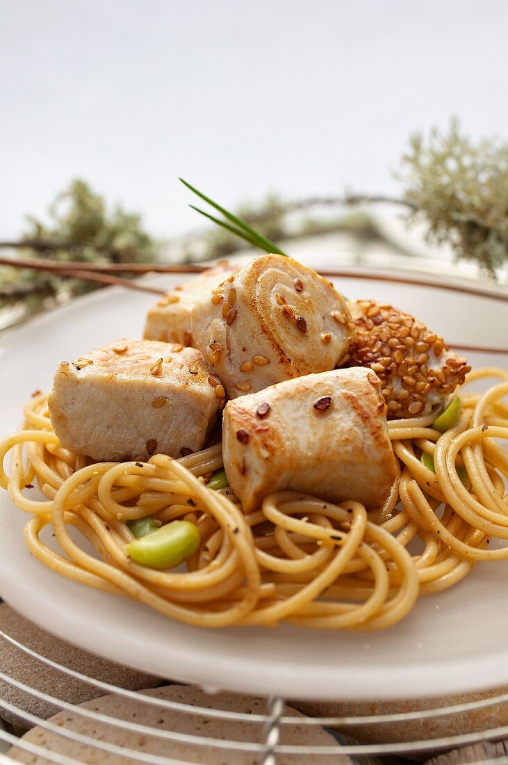 Bocconcini di tonno (Thunfischwürfel, Italien) mit Sesam auf Spaghetti