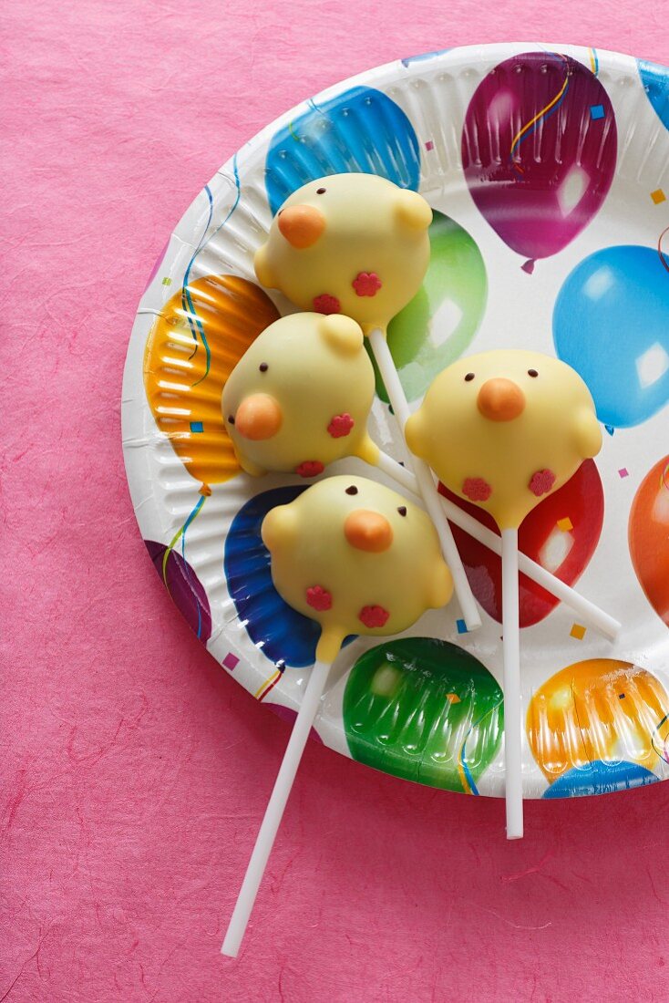 Cake Pops (Küken) auf buntem Pappteller