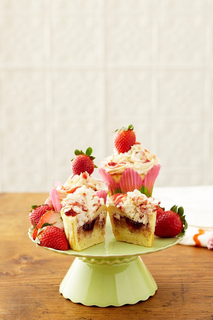 Strawberry Shortcake Cupcakes on a Pedestal Dish; One Halved