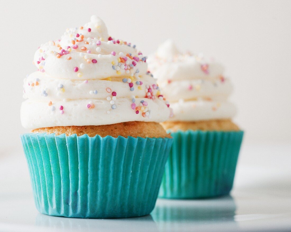 Cupcakes topped with icing and sugar pearls