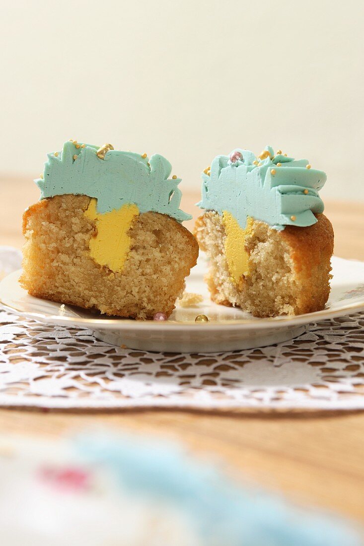 Gefüllter Cupcake mit Zitronen-Butter-Creme und türkisfarbenem Topping