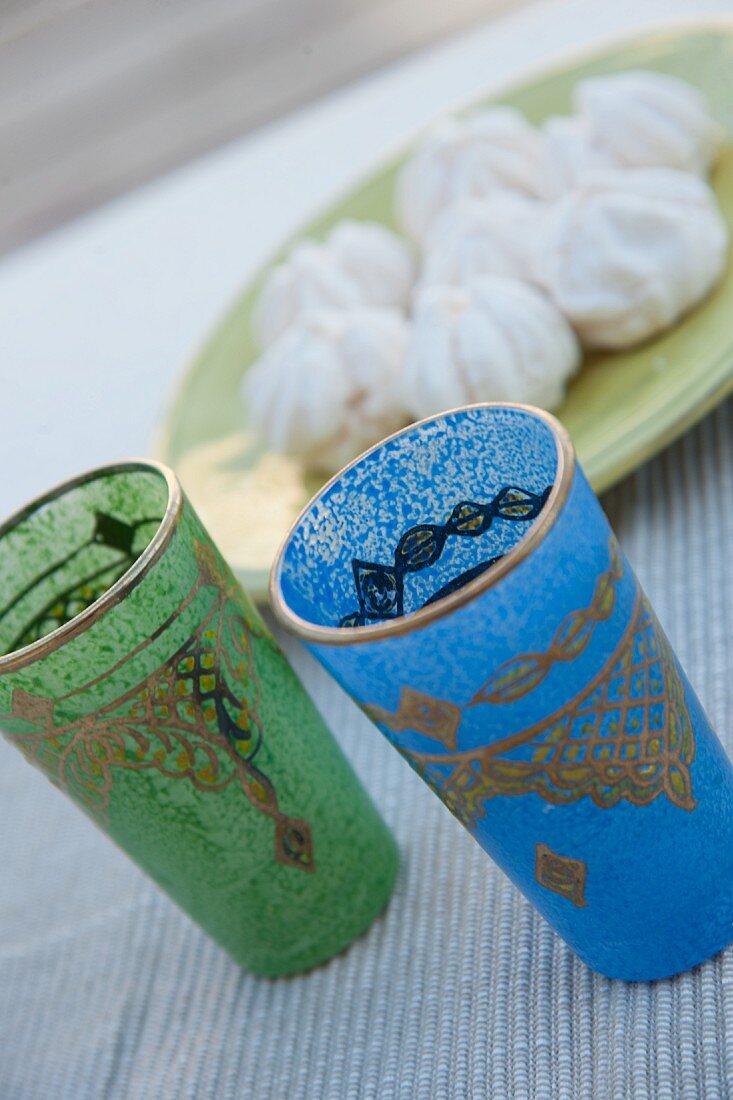 Farbige Teegläser mit orientalischem Muster neben Schale mit Süssigkeiten